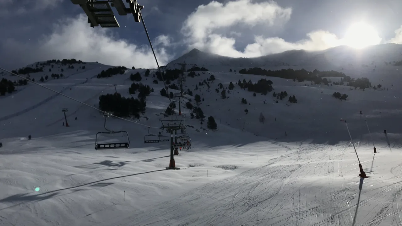 A chairlift above the pistes at Baqueira Beret on a bright winter day