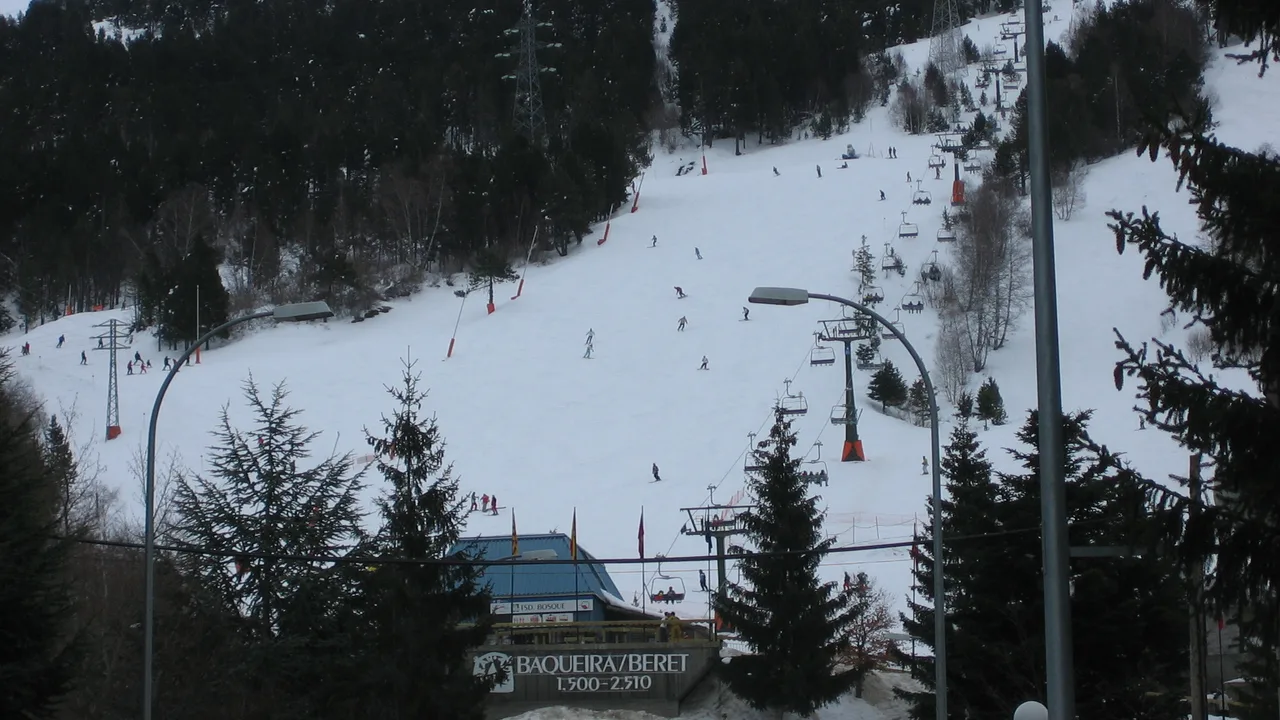 The Baqueira Beret resort base and its lifts, with skiers on the slope above