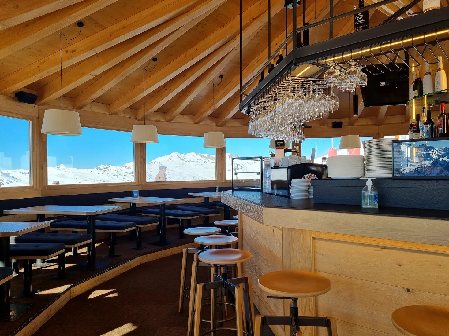 The wood-lined bar of Bar-Restaurante 2.200 with big windows onto the snowy Baqueira peaks at 2,200 m