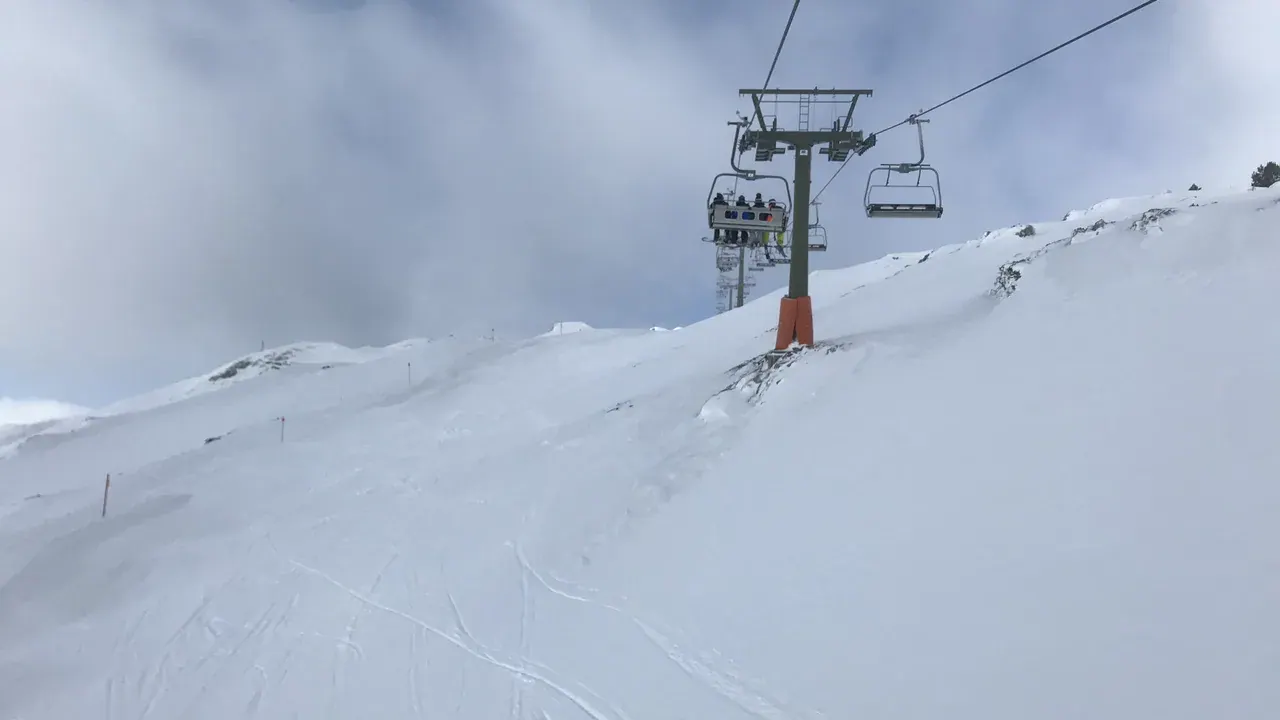 A chairlift climbing a snowy slope at Baqueira Beret