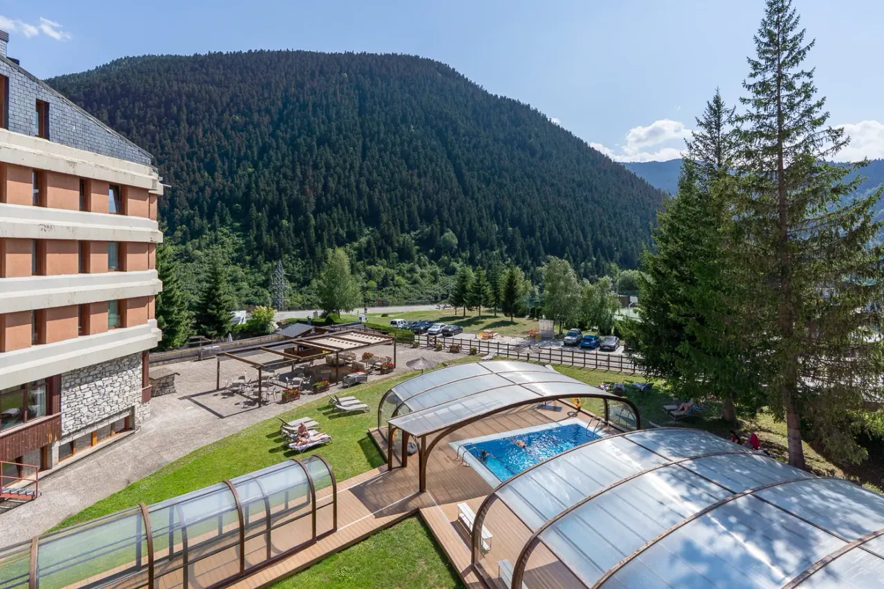 The Hotel Montarto with its covered outdoor pool and terrace, set against a forested Aran mountainside