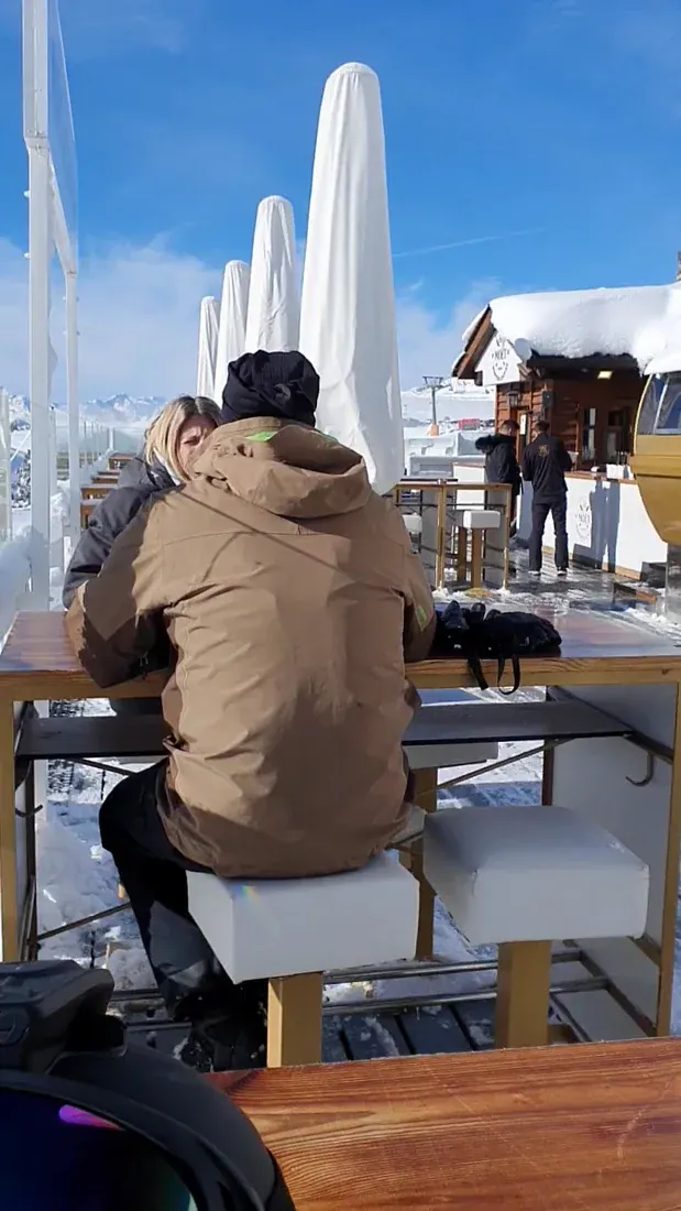 The slope-side Moët lounge on the Beret snow — a wooden chalet with Moët branding, high tables and skiers in the sun