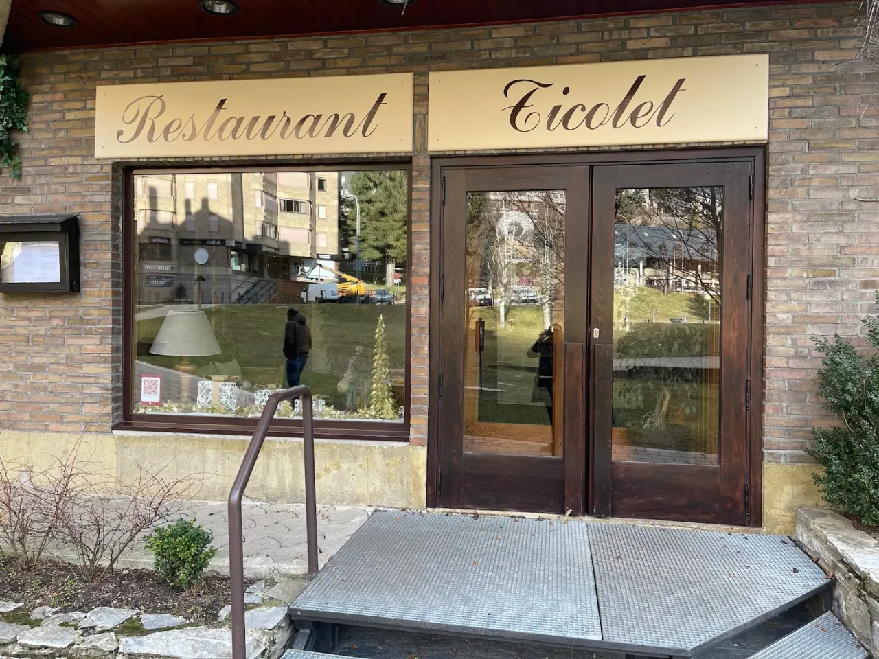 The brick facade and gold 'Restaurant Ticolet' sign above the entrance at the Baqueira 1500 base