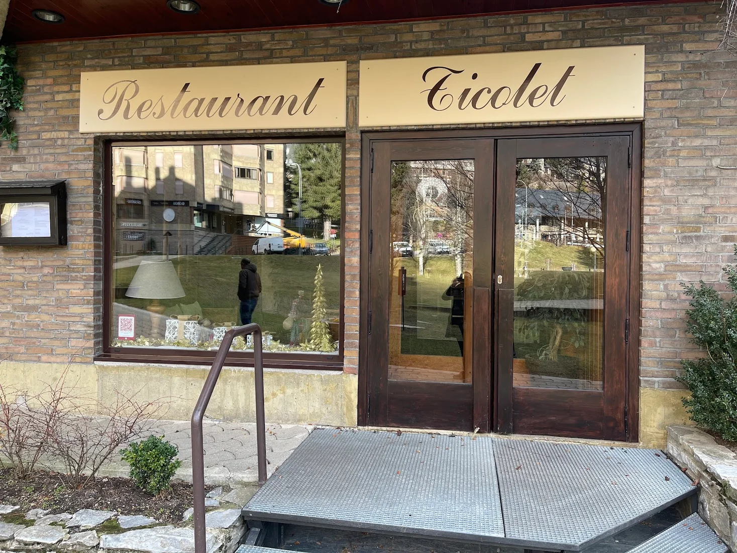 The brick facade and gold 'Restaurant Ticolet' sign above the entrance at the Baqueira 1500 base